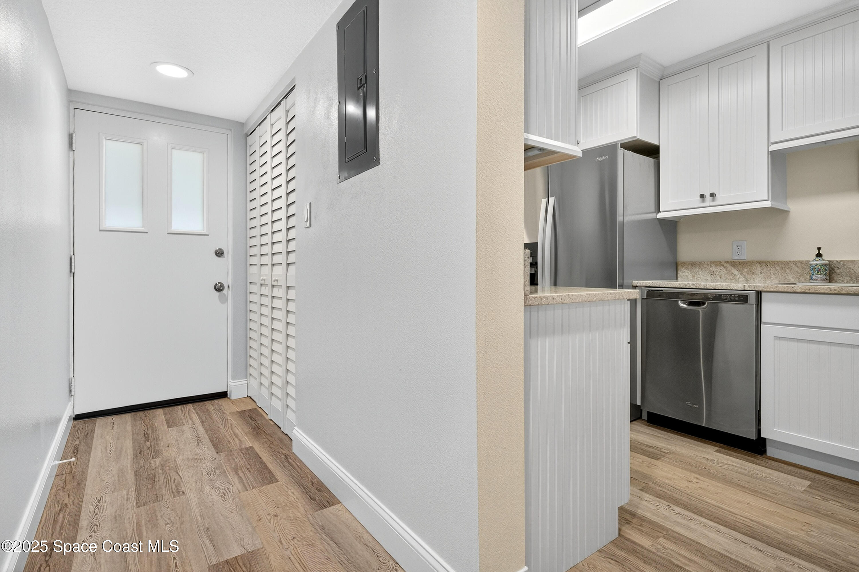 383 North Atlantic Avenue, Unit 105 Cocoa Beach, FL 32931 - Photo 8 of 67 a view of a kitchen with white cabinets and wooden floor