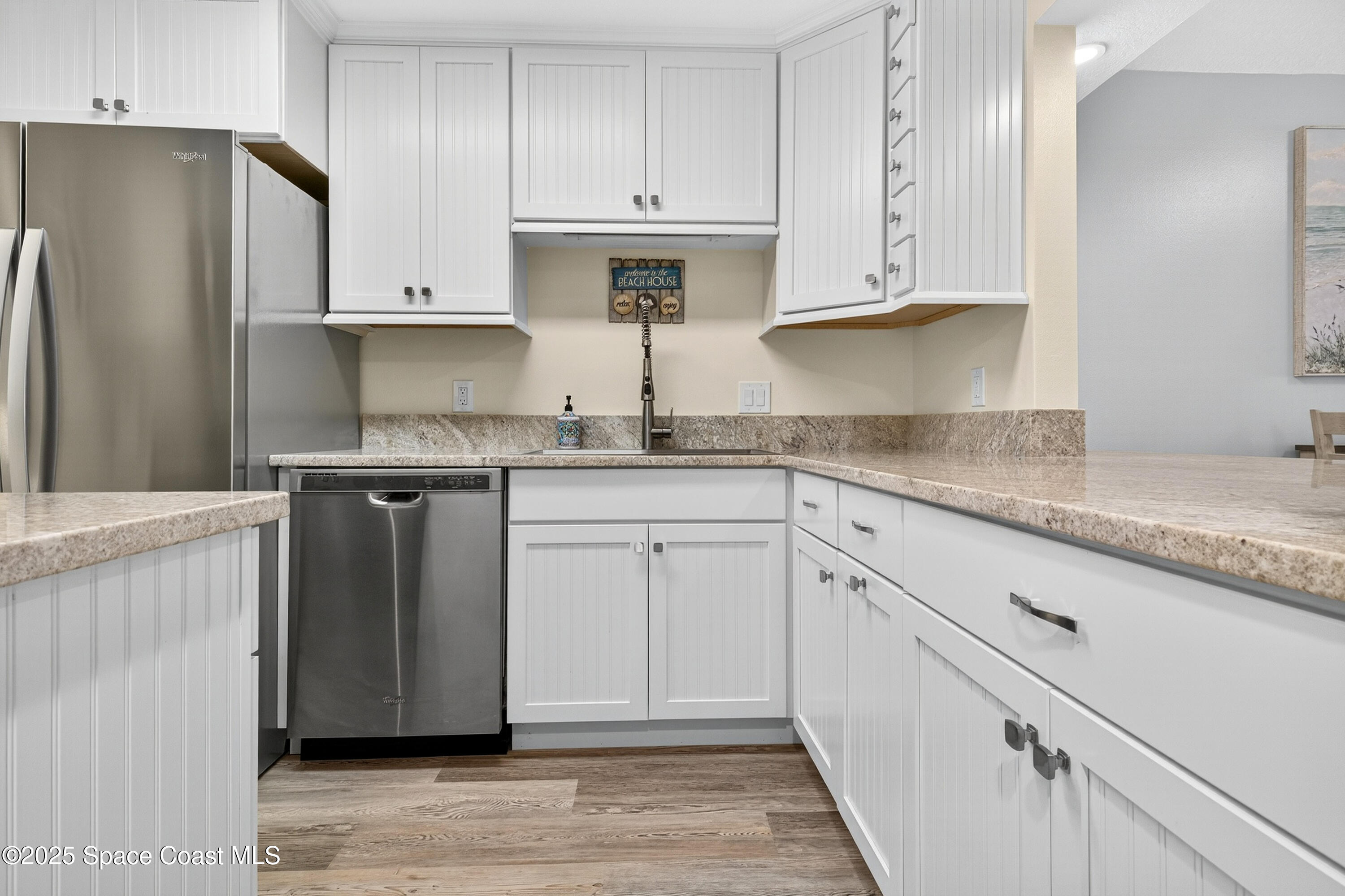 383 North Atlantic Avenue, Unit 105 Cocoa Beach, FL 32931 - Photo 9 of 67 a kitchen with stainless steel appliances granite countertop a refrigerator sink and cabinets