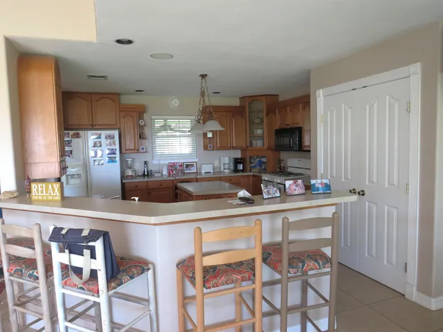 a kitchen with stainless steel appliances granite countertop a sink and a refrigerator