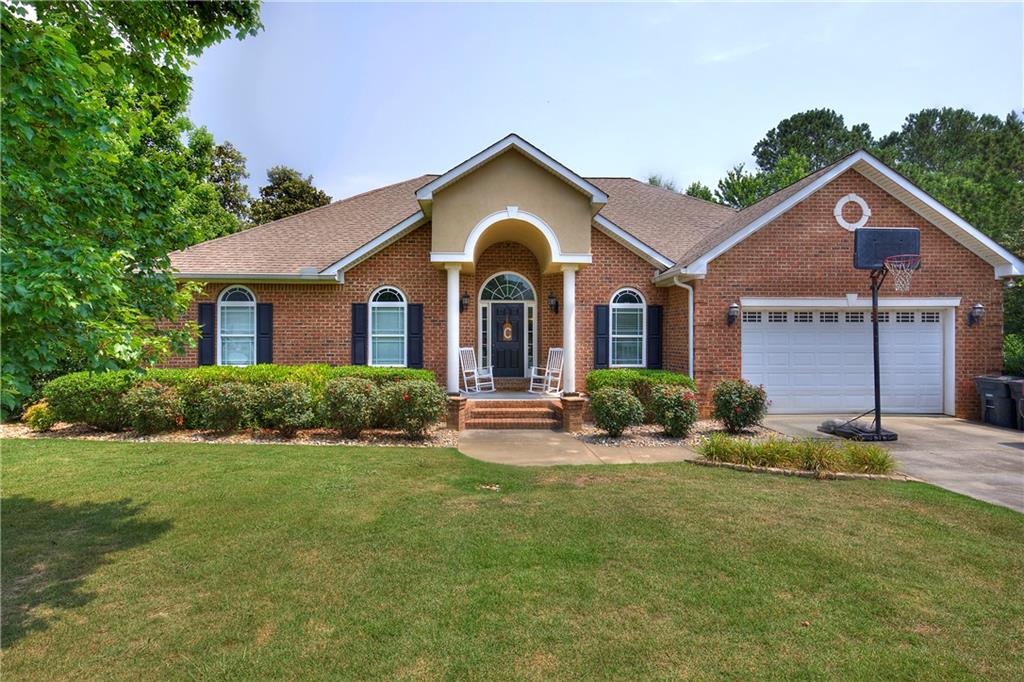 a front view of a house with yard and green space