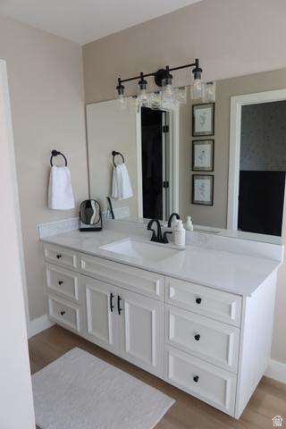 1204 North 3020th Street West Provo, UT 84601 - Photo 30 of 35 Expansive vanity featuring a white countertop with an undermount sink, white cabinetry with black hardware, a large wall-mounted mirror, and a modern four-light fixture