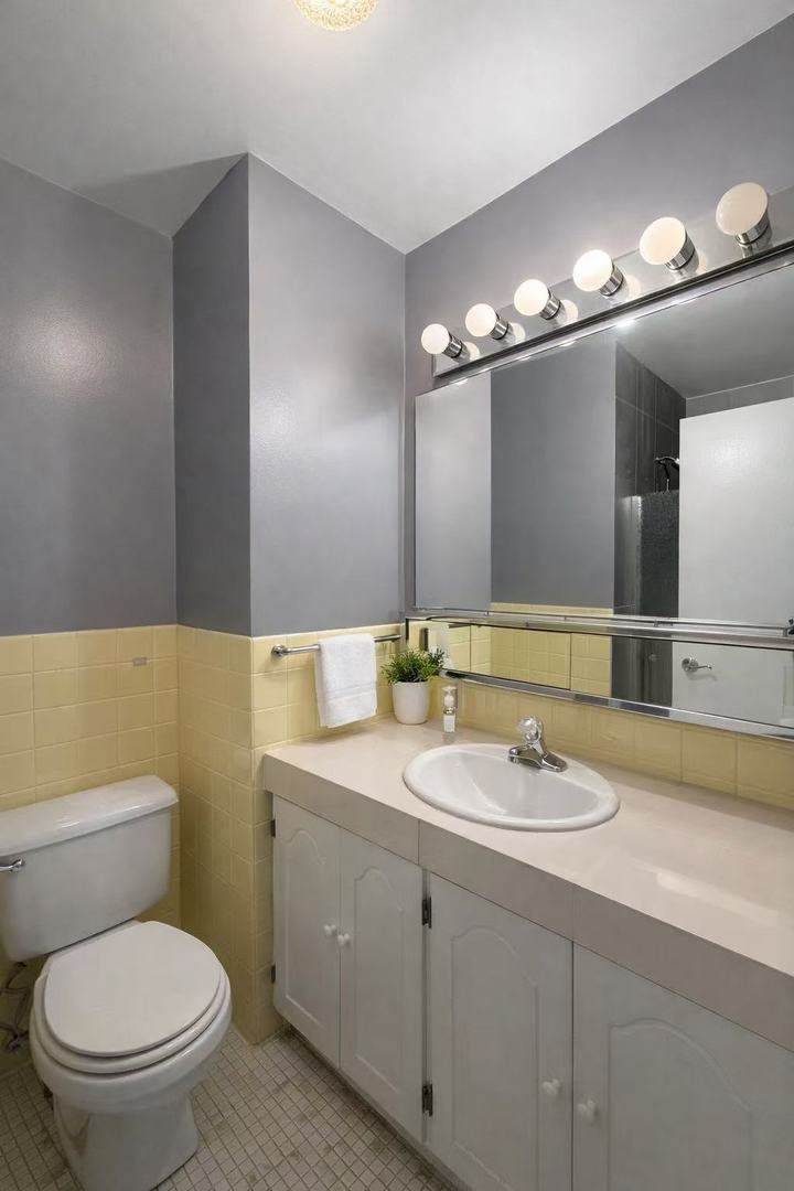 6301 North Sheridan Road, Unit 15B Chicago, IL 60660 - Photo 8 of 11 a bathroom with a toilet sink and mirror