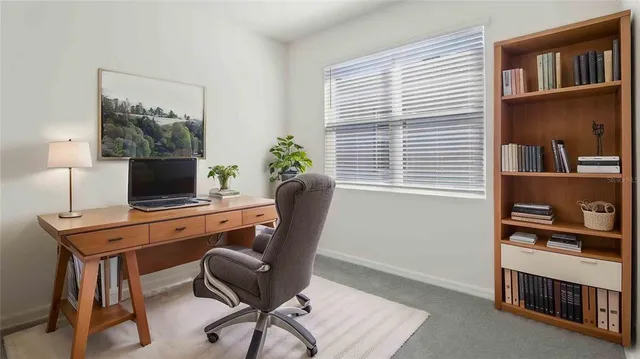 a view of a workspace with furniture and a window