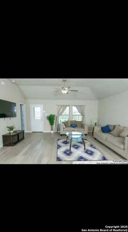 a view of kitchen island a sink and wooden floor