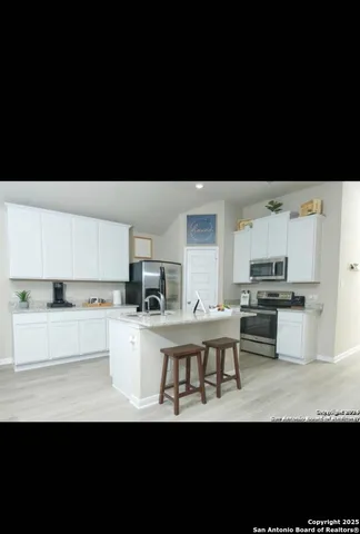 a open kitchen with stainless steel appliances a sink and a refrigerator