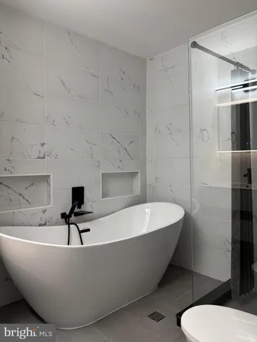 a white tub sitting next to a toilet