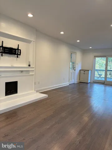 an empty room with wooden floor and fireplace