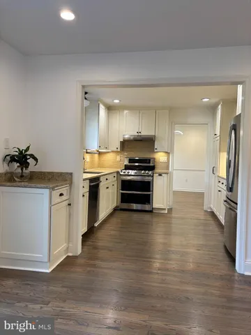 a kitchen with wooden floors and stainless steel appliances