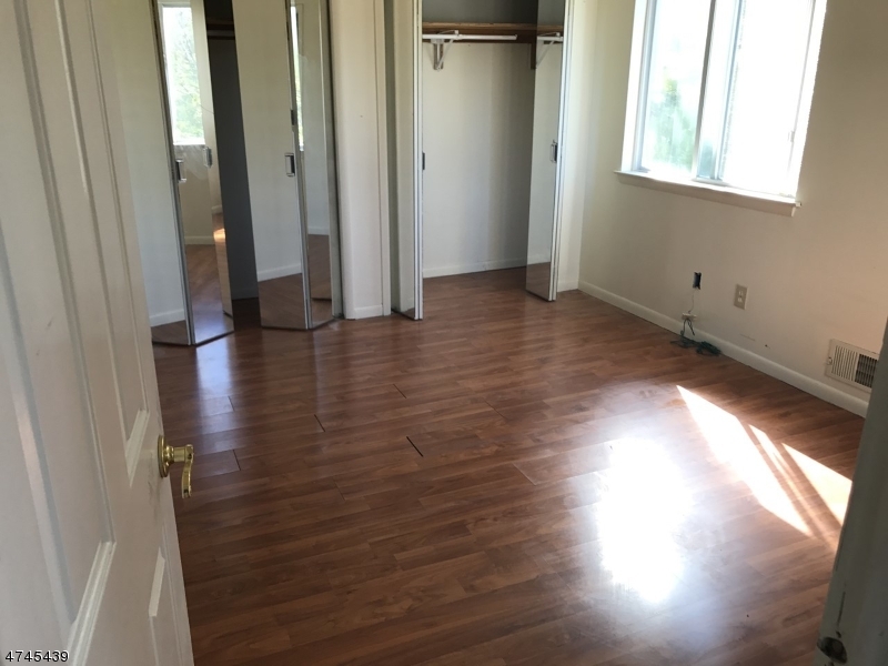 15 Falcon Ridge Way North, Unit 15 Hamburg, NJ 07419 - Photo 2 of 4 an empty room with wooden floor and windows