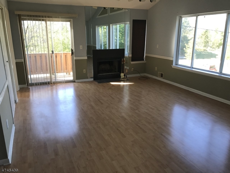15 Falcon Ridge Way North, Unit 15 Hamburg, NJ 07419 - Photo 3 of 4 an empty room with wooden floor and windows