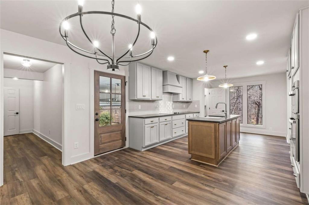 7448 Berea Road Winston, GA 30187 - Photo 18 of 43 a kitchen with stainless steel appliances granite countertop a refrigerator a sink dishwasher a stove and a dining table with wooden floor