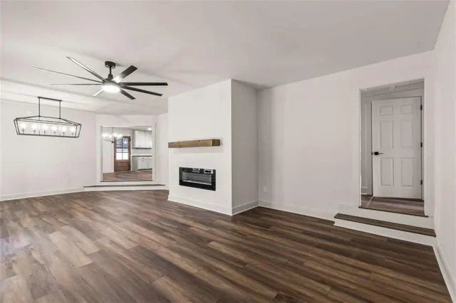 a view of a livingroom with wooden floor and a ceiling fan