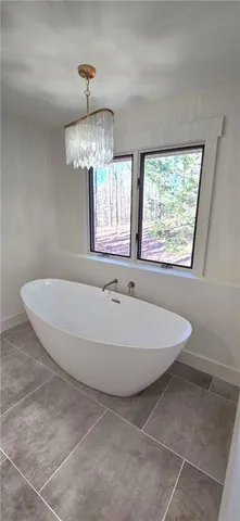 a spacious bathroom with a bathtub and chandelier