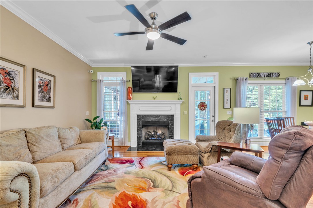 648 Mountain View Road Williamston, SC 29697 - Photo 3 of 42 A well-lit living space features a fireplace and crown molding, offering comfort and style.