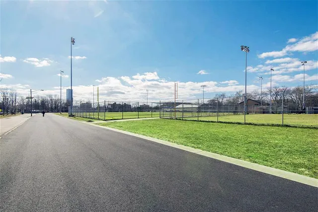 a view of a house with a big yard and palm trees