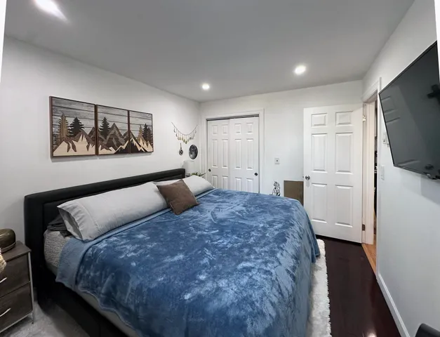 a bedroom with a large bed and a flat screen tv