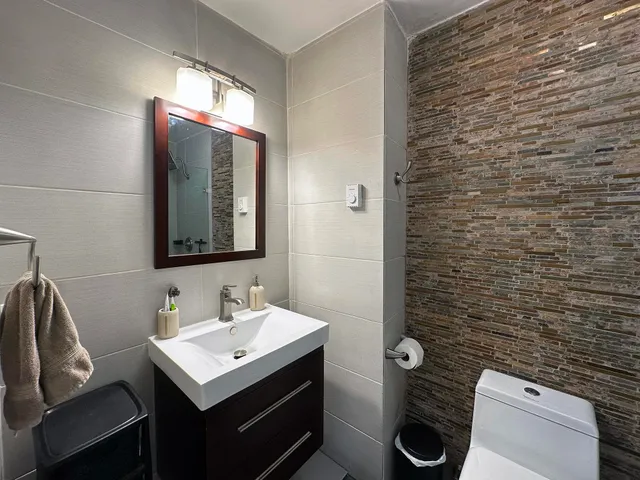 a bathroom with a sink mirror and toilet
