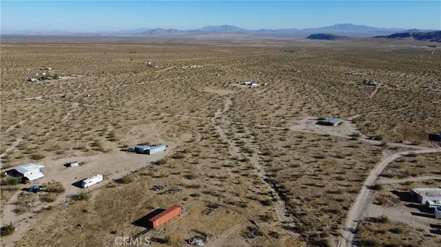 a view of a dry field with mountains in the background