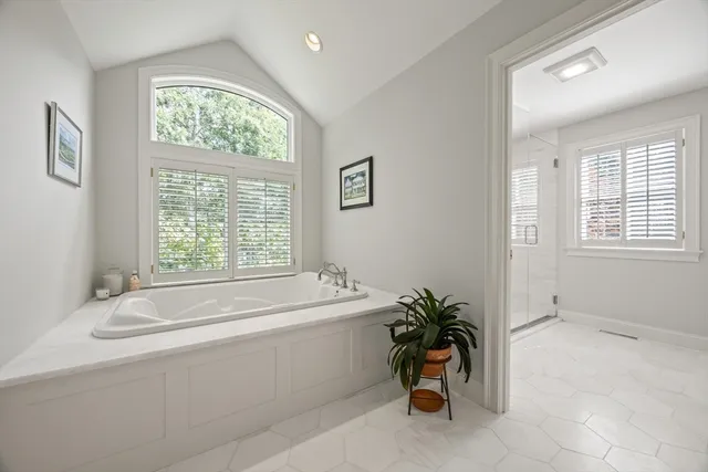 a bathroom with a tub sink and a window