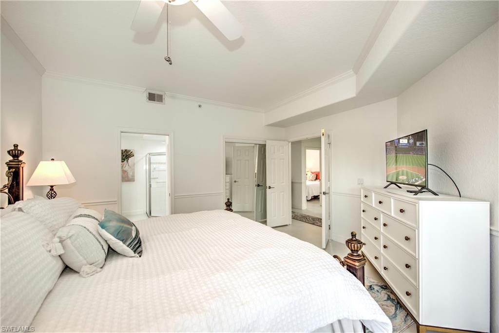 8385 Whisper Trace Way, Unit N104 Naples, FL 34114 - Photo 10 of 16 a bedroom with a bed and a flat tv screen on dresser