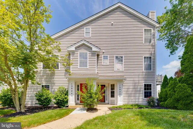a view of a house with a yard and potted plants