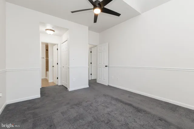 an empty room with chandelier fan