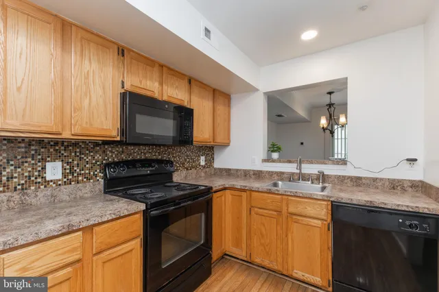 a kitchen with stainless steel appliances granite countertop a sink stove and microwave