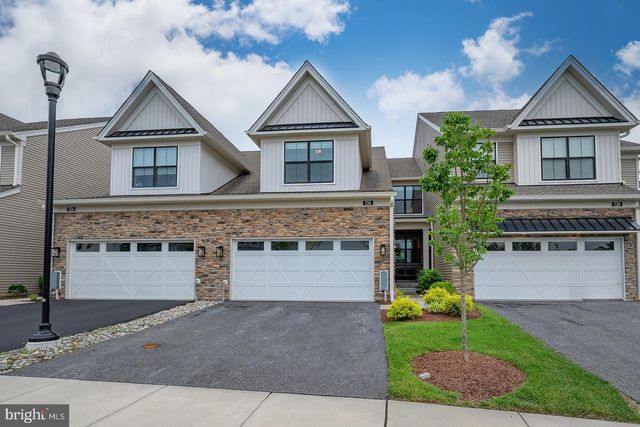 a front view of a house with a garden and garage