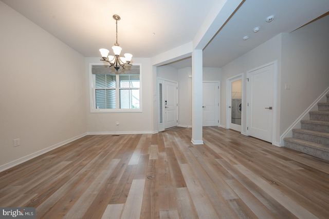 a view of a livingroom with a furniture chandelier and wooden floor