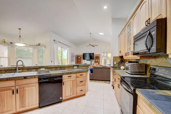 a kitchen with stainless steel appliances granite countertop a stove sink and cabinets