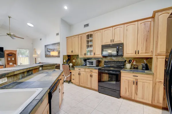 a kitchen with stainless steel appliances white cabinets sink and a stove