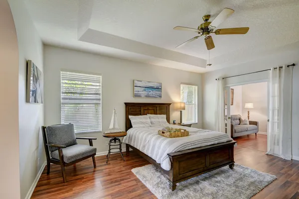 a bedroom with a bed a couch and a chandelier