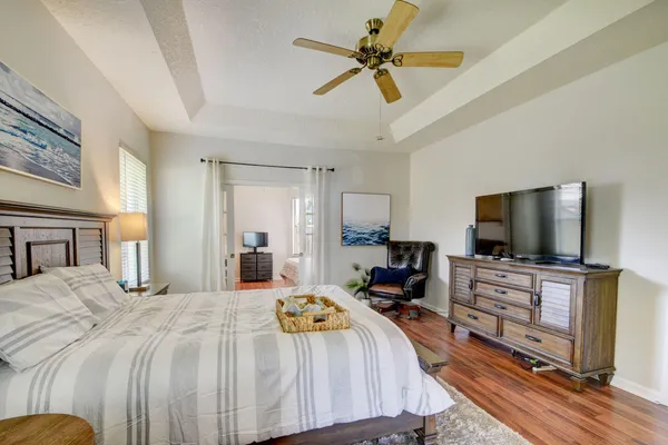 a bedroom with a bed a flat screen tv and a chandelier