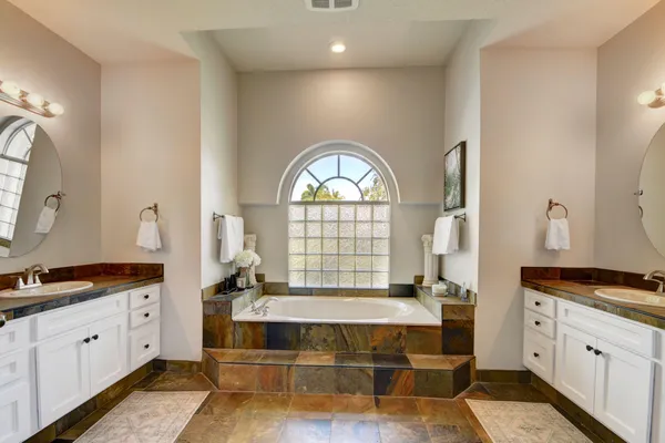 a spacious bathroom with a double vanity sink and a window