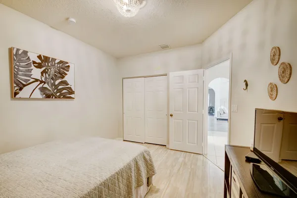 a bedroom with a bed and a flat tv screen on the dresser
