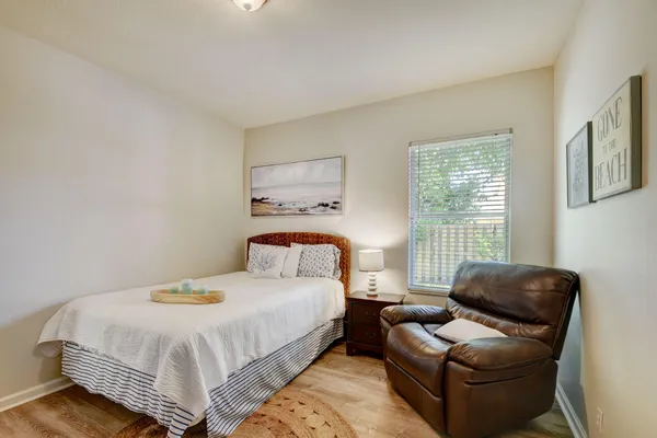 a bedroom with a bed and a couch with windows