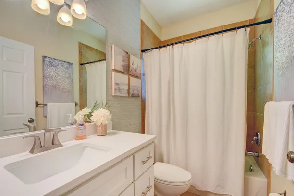 a bathroom with a sink a toilet and shower curtain