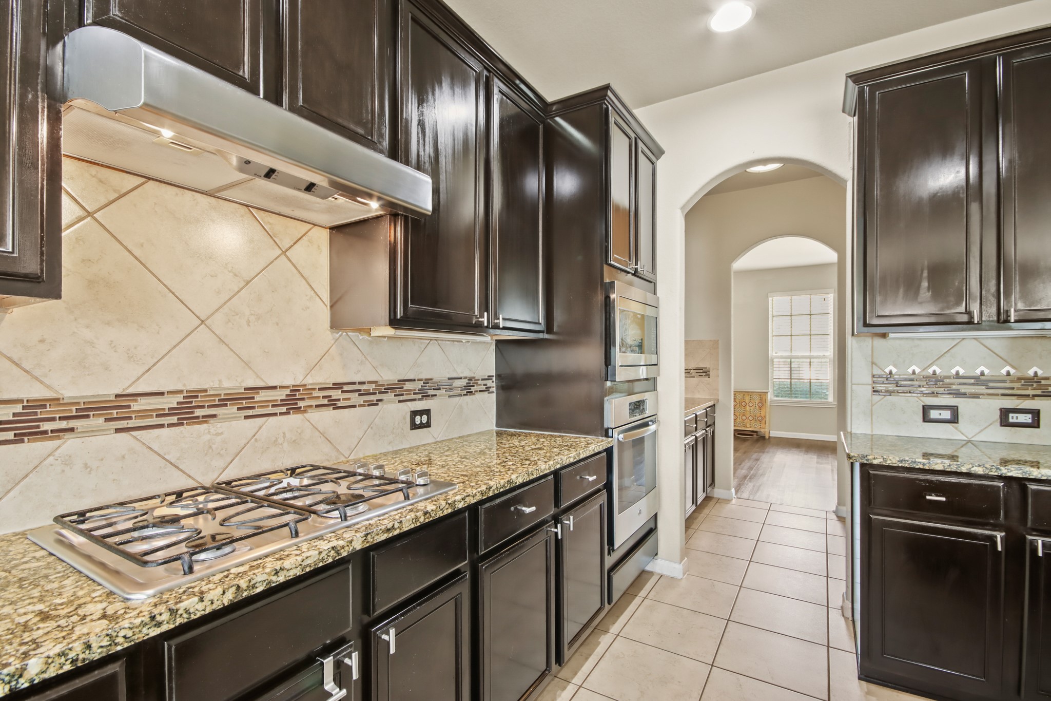 25407 Terrain Park Drive Spring, TX 77373 - Photo 14 of 33 a kitchen with a stove a sink and a refrigerator