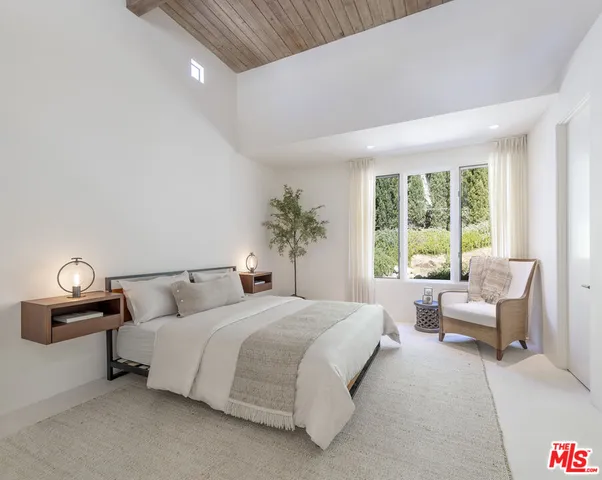 a bedroom with bed and a large window