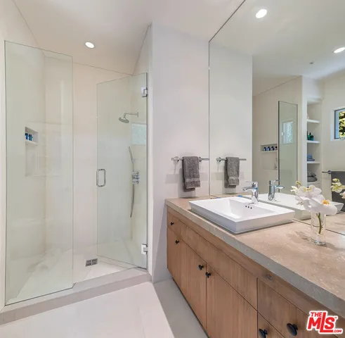 a bathroom with a shower sink and mirror
