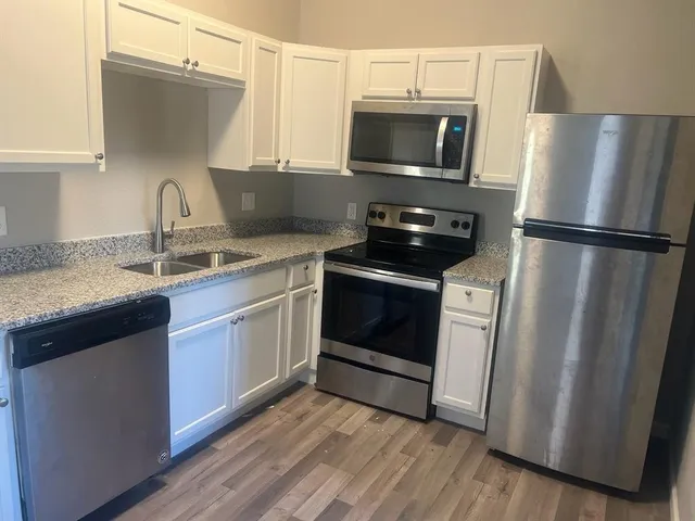 a kitchen with a sink a microwave a refrigerator and cabinets