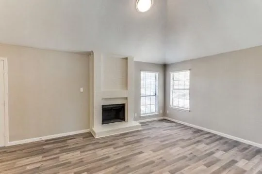 a view of empty room with wooden floor and fireplace