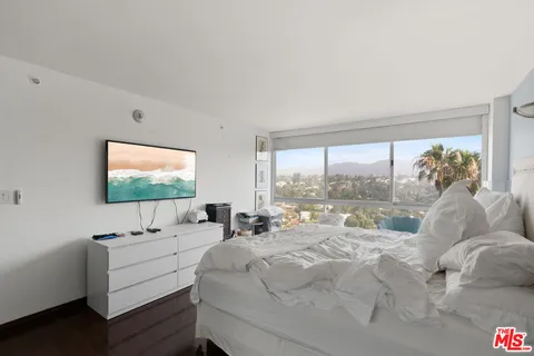 a living room with a large window and a flat screen tv