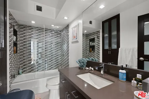 a bathroom with a bathtub shower sink vanity and toilet