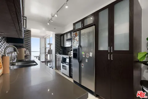 a kitchen with stainless steel appliances granite countertop a refrigerator and a sink