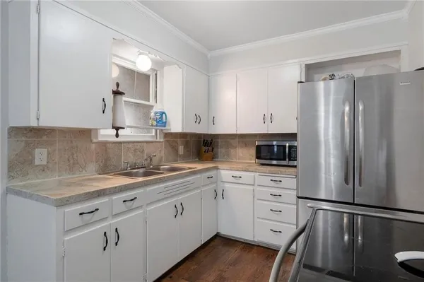 a kitchen with white cabinets and white appliances