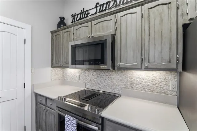 a kitchen with granite countertop a stove a sink and a microwave