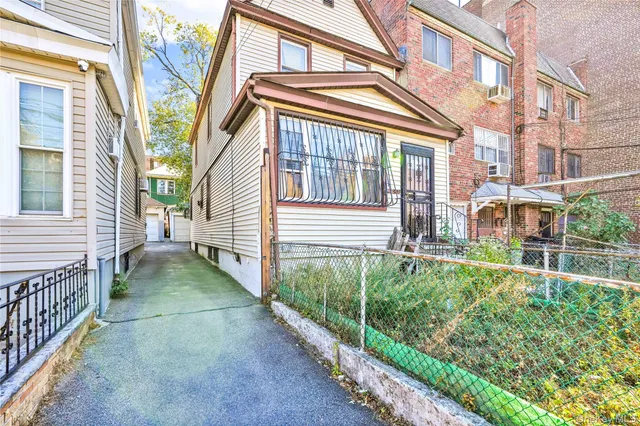 a view of a house with a small yard and wooden floor and fence