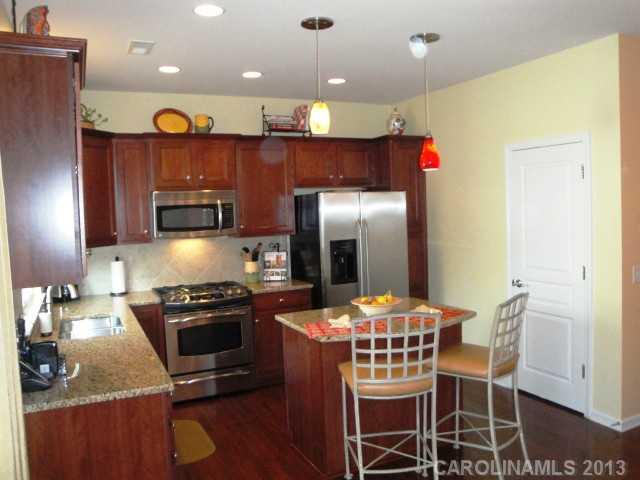668 6th Baxter Crossing, Unit 111 Fort Mill, SC 29708 - Photo 8 of 16 a kitchen with kitchen island a refrigerator and a stove