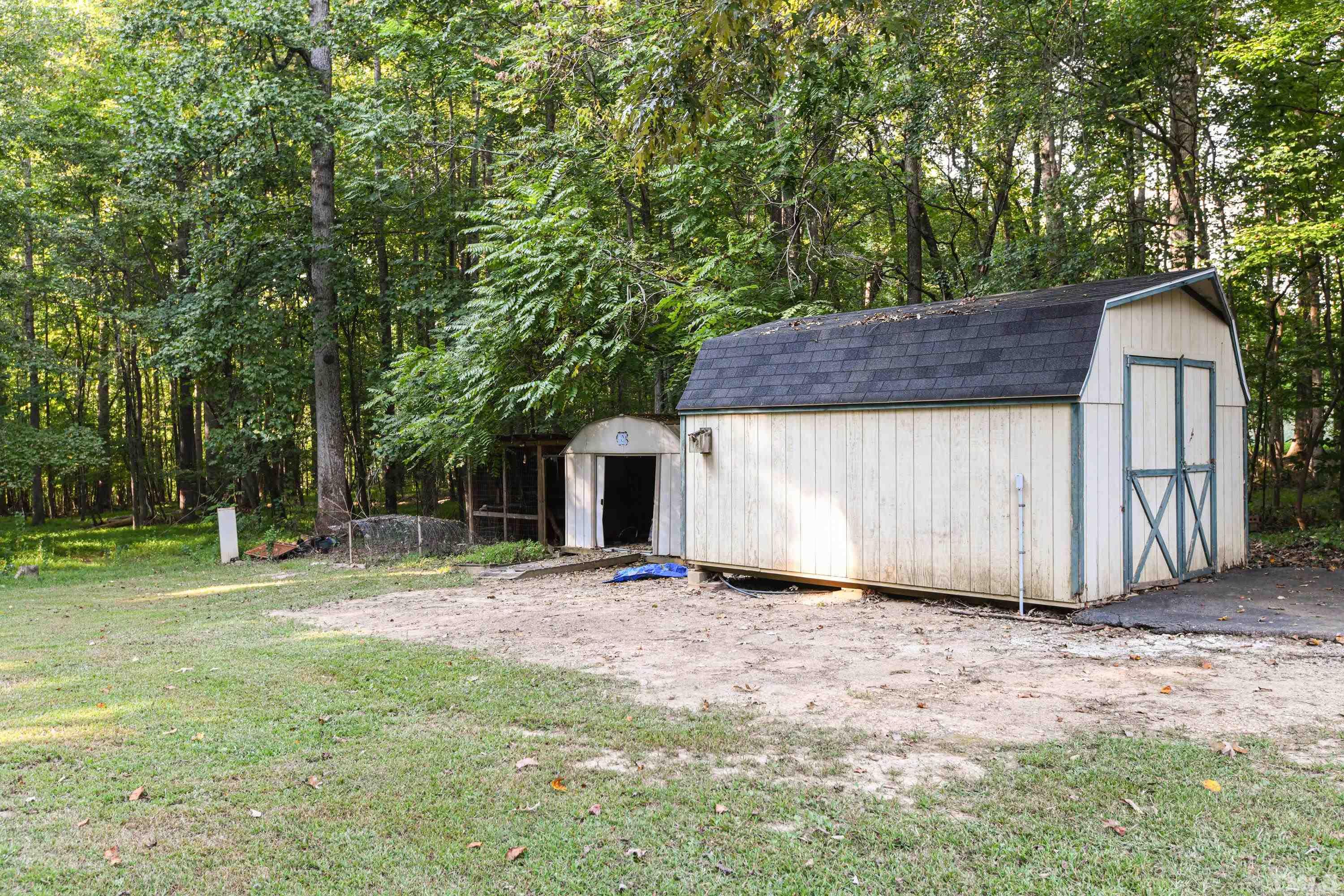 1516 Bill Poole Road Rougemont, NC 27572 - Photo 16 of 17 a backyard of a house with wooden fence and large trees